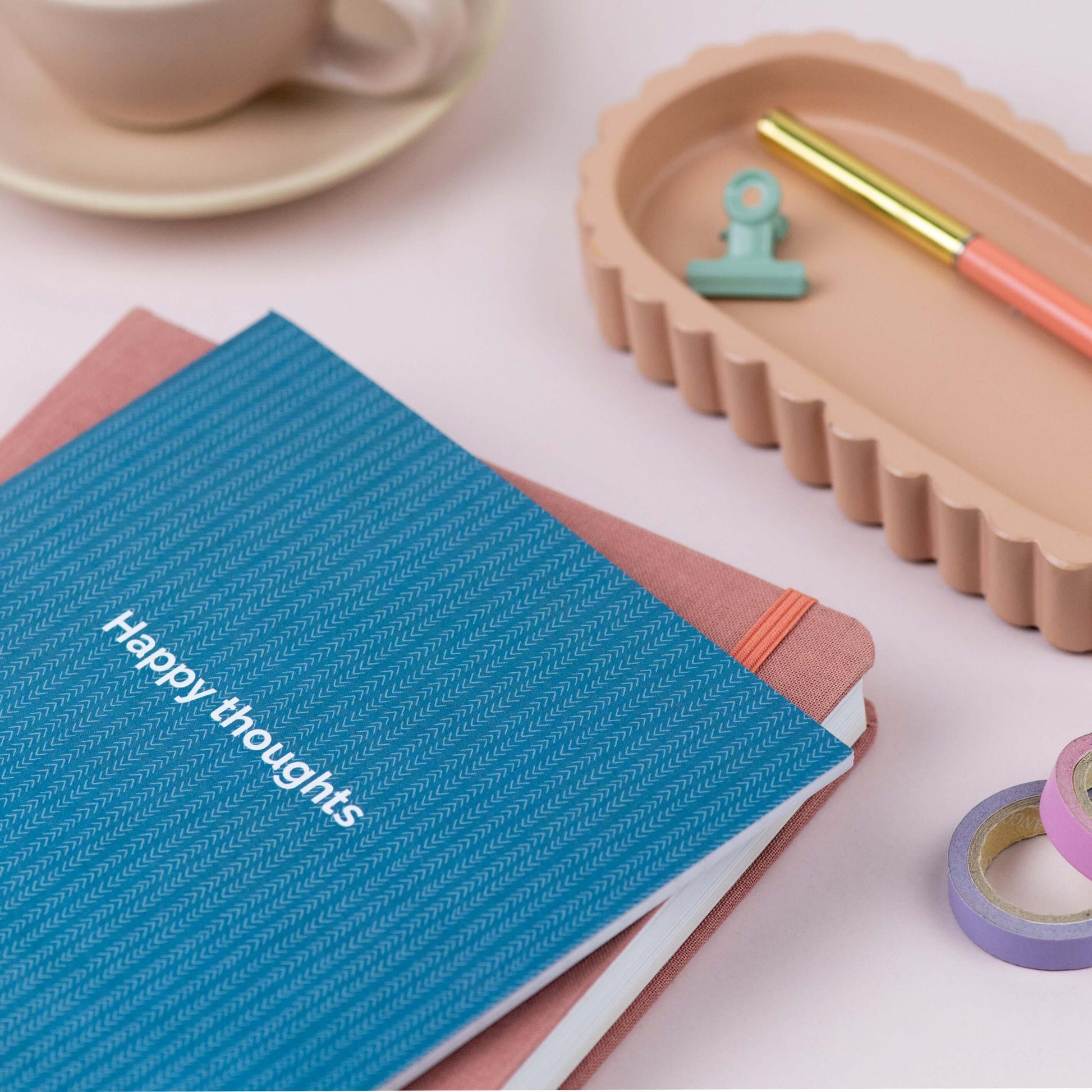 Close-up of green notebook with 'Happy Thoughts' text